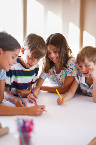 istock Group of children drawing on white paper whit felt tip pens 1335004151