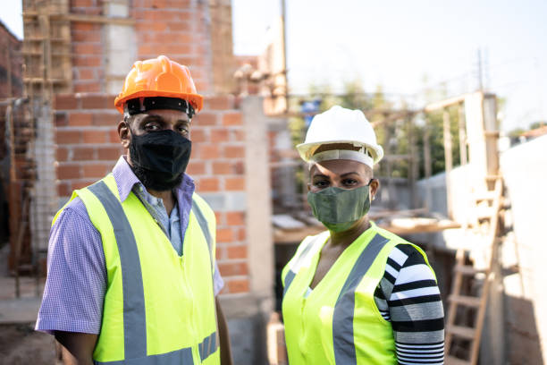istock Portrait of construction workers using protective face mask at a building site 1335005670