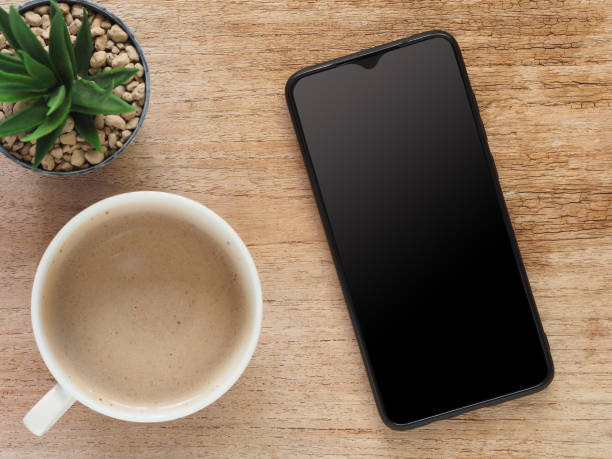 istock Top view, Smartphone with blank screen and hot coffee cup, cactus on rustic wooden. Flat lay, space for your text. 1335005802