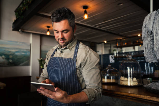 istock handsome caucasian waiter scrolling on digital ipad logging into account while standing in cafe 1335006033