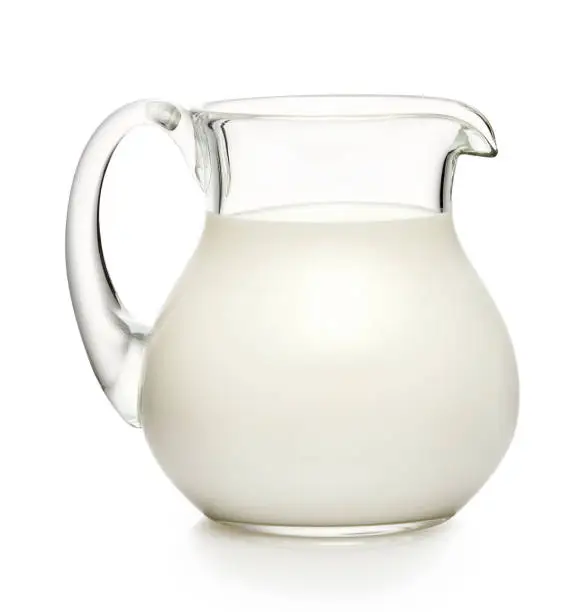 Glass jug of milk isolated on white background