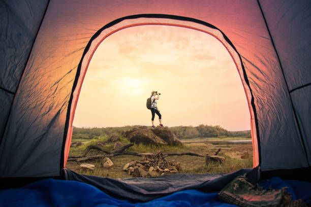 View looking from inside tent, Woman tourist backpack standing on the rock