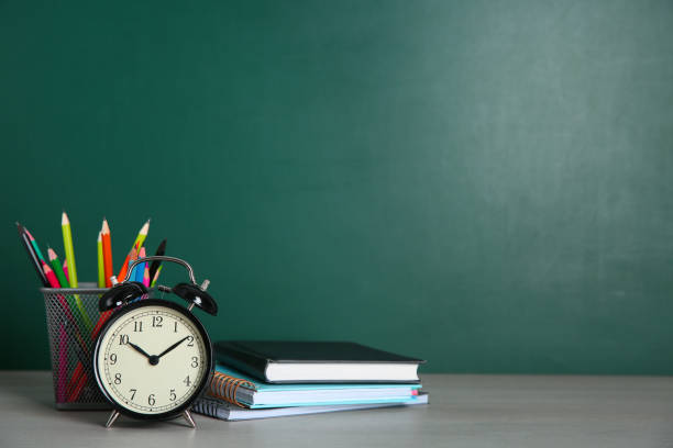 istock Alarm clock and school stationery on white wooden table, space for text. Doing homework 1335009588