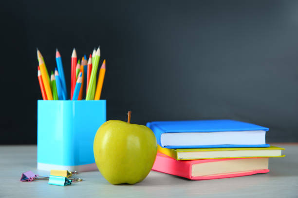 istock Apple and school stationery on white wooden table. Doing homework 1335009661