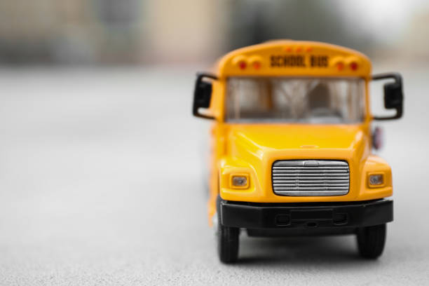 vista ravvicinata dello scuolabus giocattolo giallo all'aperto, spazio per il testo. trasporti per studenti - school bus defocused education bus foto e immagini stock