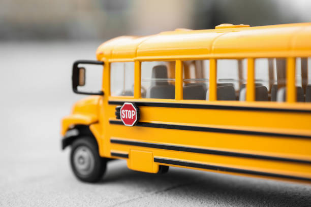 scuolabus giocattolo giallo su sfondo sfocato, primo piano. trasporti per studenti - school bus defocused education bus foto e immagini stock