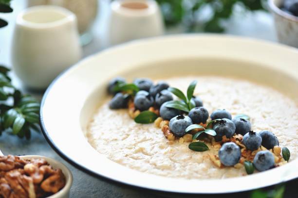 クルミとブルーベリーのオートミール。健康的な朝食。 - oat oatmeal rolled oats oat flake ストックフォトと画像