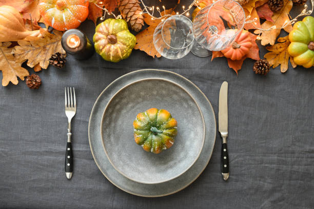 istock Thanksgiving day table setting with empty plate as mockup decorated fallen leaves, pumpkins. 1335014357