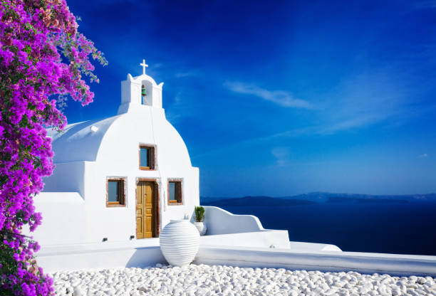 beautiful details of Santorini island, Greece beautiful details of Santorini island - typical house with white walls with flowers and blue Aegan sea, Greece aegean islands photos stock pictures, royalty-free photos & images