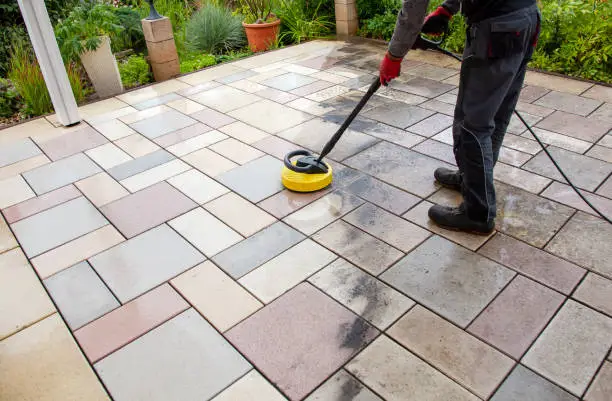 Photo of Cleaning stone slabs on patio with the high-pressure cleaner.