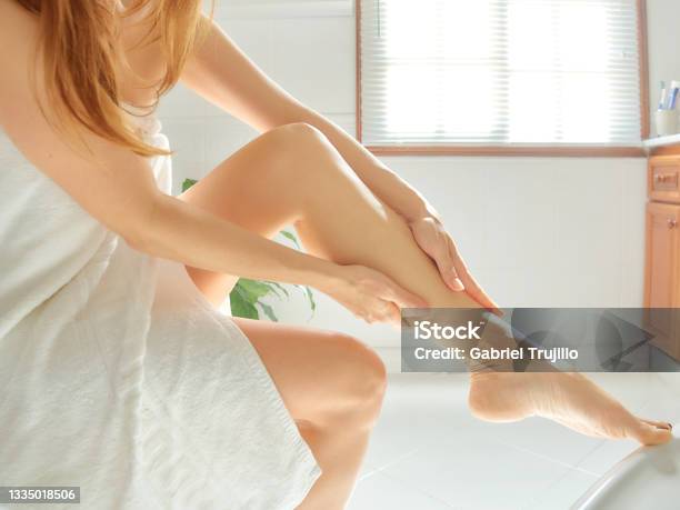 Wellness And Skin Care Concept Young Woman Massaging Her Legs After Depilation In The Bathroom Stock Photo - Download Image Now