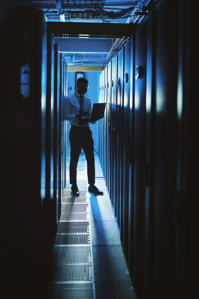 shot of a young man working in an it server room - africa blue cloud color image imagens e fotografias de stock