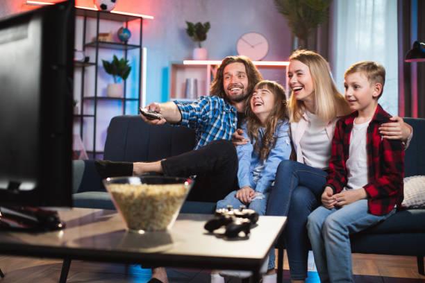 istock Cheerful family sitting on couch and watching television 1335022183