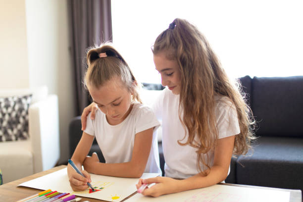 istock two sisters having a good time at home. children doing creative art work. 1335023184