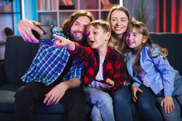 istock Cheerful parents with kids using mobile for taking selfie 1335023199
