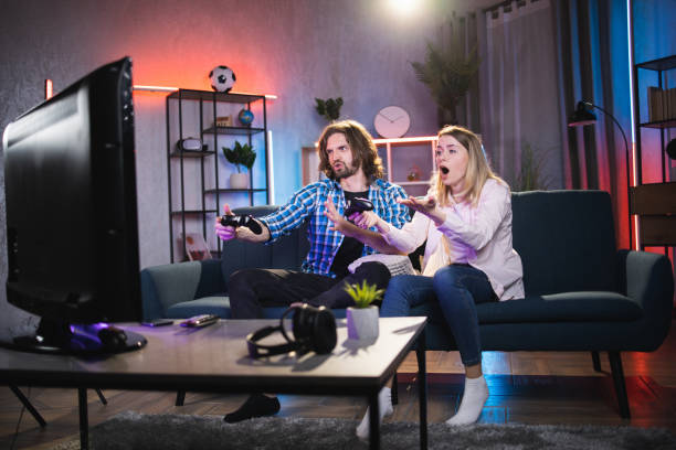 istock Young couple playing video games at home 1335023461