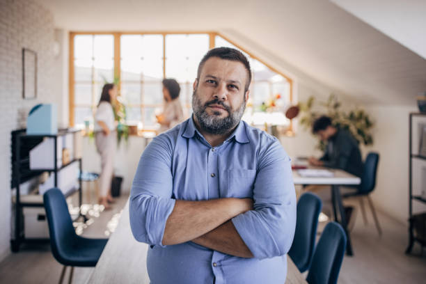 Man in modern office Diverse group of people, portrait of a Caucasian man standing in front of his colleagues in modern office. overweight stock pictures, royalty-free photos & images