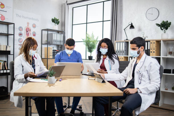 4 명의 다인종 의사가 환자의 의료 기록을 검토하고 현대 사무실에서 일합니다. - trainee computer medical student student 뉴스 사진 이미지