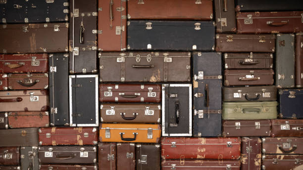 istock Vintage suitcase stacks background. Old antique leather travel bags pattern 1335027149