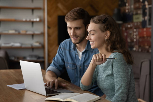 istock Mentor man training intern girl at laptop 1335027181