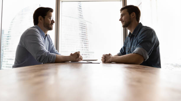istock Two businessmen, business competitors, opponents sitting opposite 1335027222