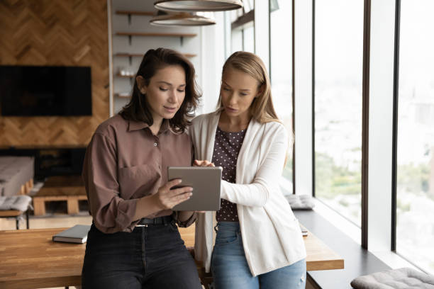 istock Female office employee showing work content on tablet 1335027279