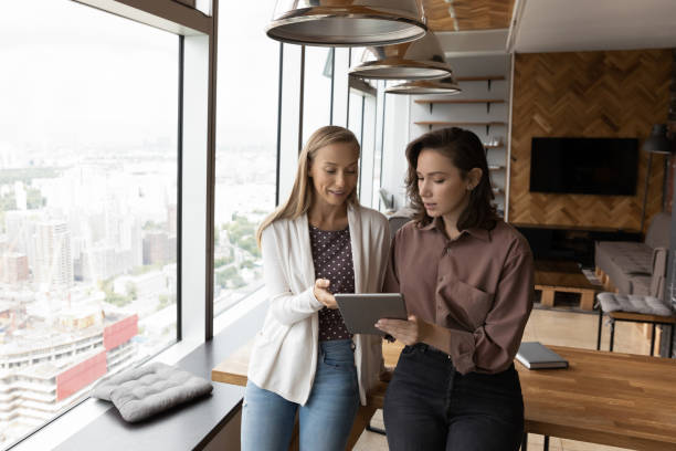 istock Company mentor training new hired employee, intern, explaining using app 1335027283