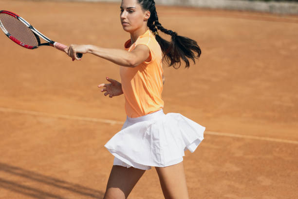 istock One beautiful young sportswoman, professional tennis player with racket practicing on clay tennis court in summer day. 1335029525