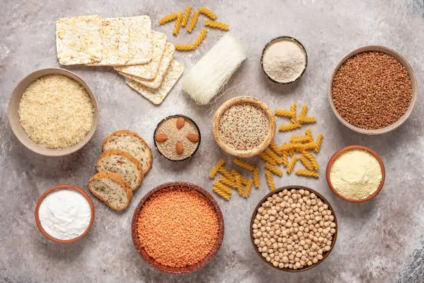 Photo of Selection of gluten free food on a rustic background. A variety of grains, flours, pasta, and bread gluten-free. Top view, flat lay.