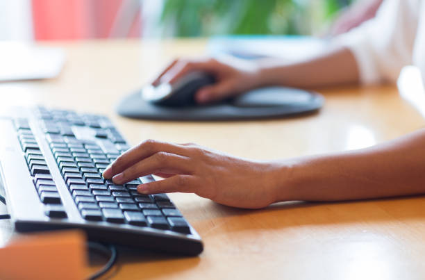 istock close up of female hands with keyboard and mouse 1335036747