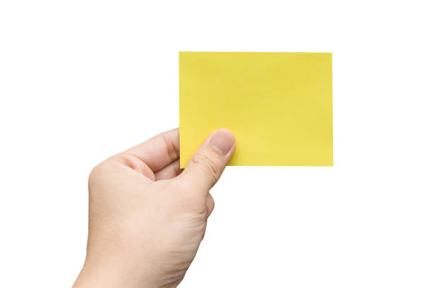 istock Hand holding yellow paper isolated on white 1335036994