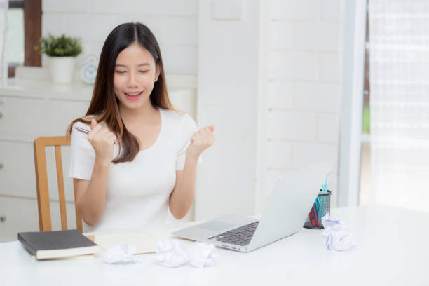istock Young asian woman confident working at home with laptop computer and thinking idea for planning, freelance happy girl excited and success using notebook thoughtful and writing, business concept. 1335037977