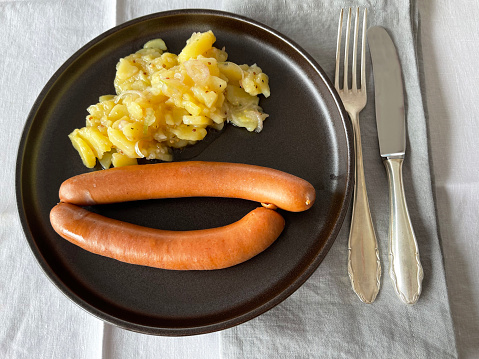 pair of wiener sausages with potato salad in plate
