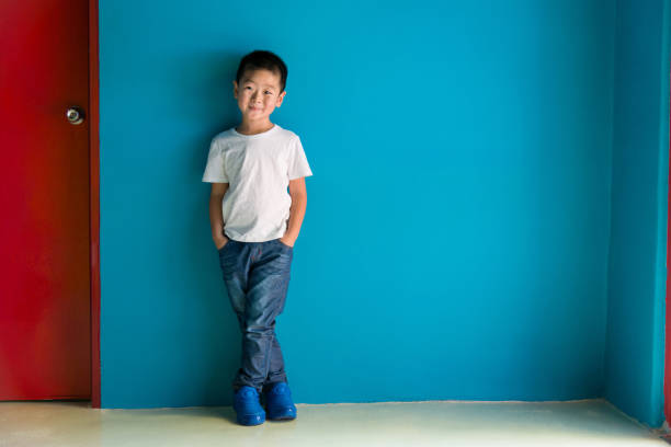 istock A cute boy standing in front of the blue wall 1335040180