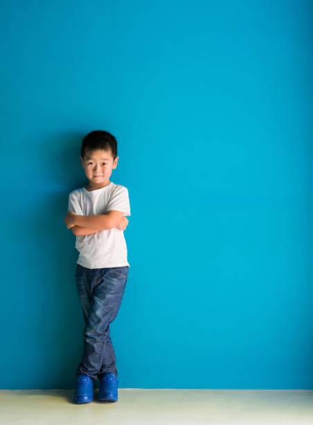 istock A cute boy standing in front of the blue wall 1335040200