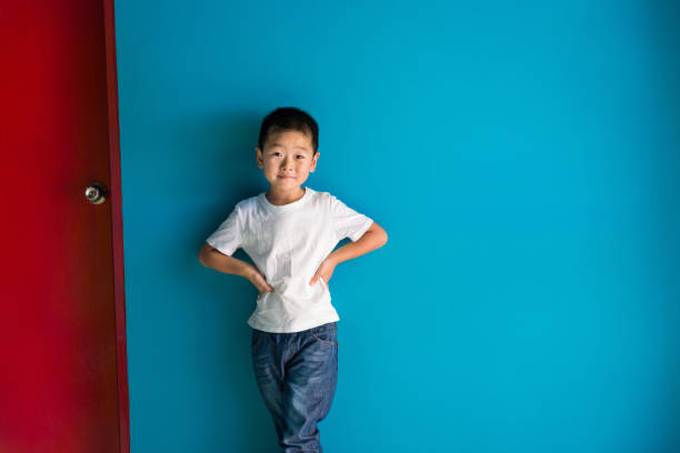 istock A cute boy standing in front of the blue wall 1335040225