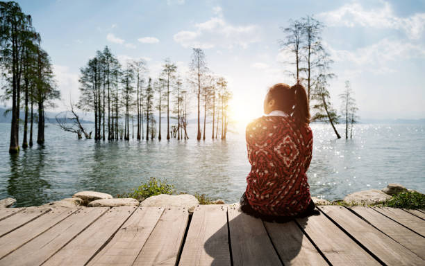 Woman sitting by the lake.