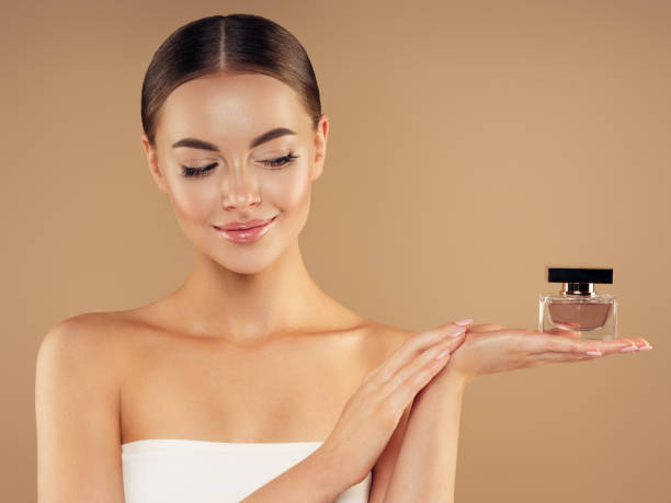 istock Young woman with clean and fresh skin presenting perfume 1335041876