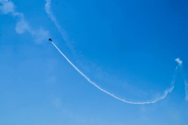 istock Stunt plane doing loops very blue sky with white smoke trail. 1335042166