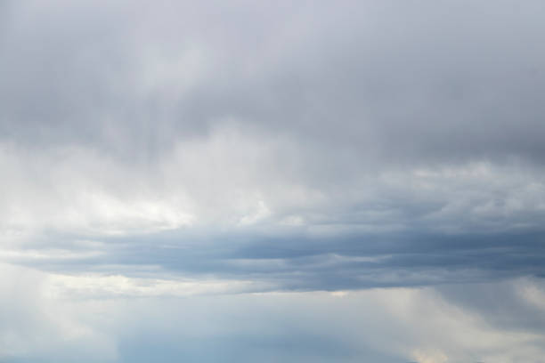 istock Stormy sky with flat bluish cloud - blue sky below and grey clouds above - before a rain shower. 1335042174