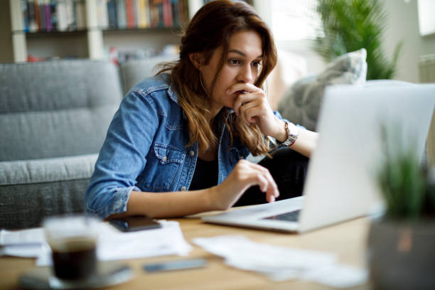 Worried young woman working at home stock photo