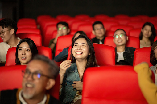 Group of people enjoying watching a movie at movie theater.