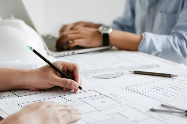 istock close up of team engineer or architect meeting for project working with partner and engineering tools on model building and blueprint in working site. Construction concept 1335049745
