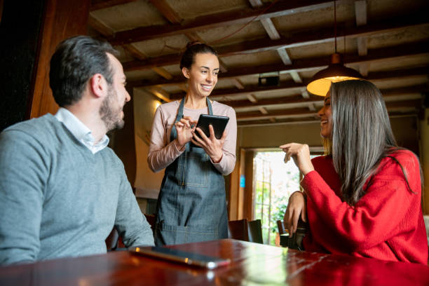 istock Waitress taking the order of a couple having dinner at a restaurant 1335052529