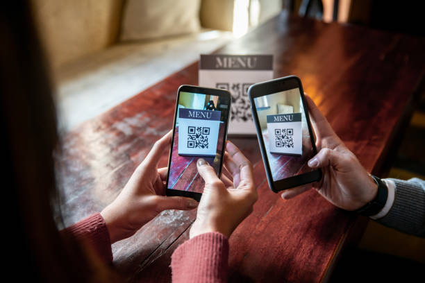 istock People at a restaurant scanning the menu with QR codes 1335052534