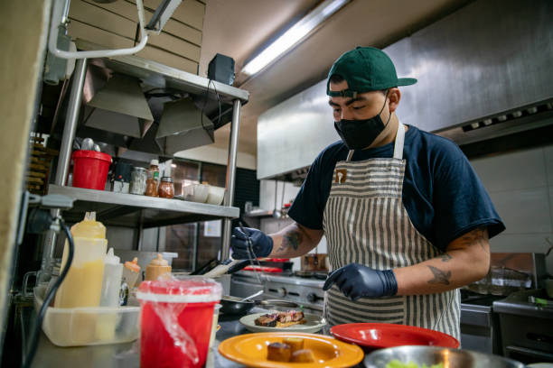 istock Chef preparing food at a restaurant wearing a facemask 1335052537