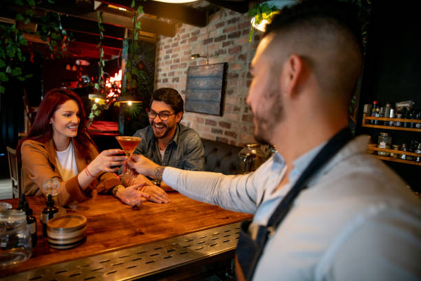 istock Bartender serving drinks to a happy couple at a bar 1335052566