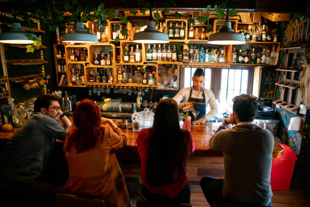 istock Bartender at the bar making cocktails for people 1335052573