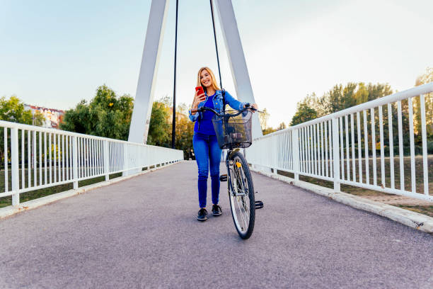 istock Woman with a bicycle using cell phone 1335058224