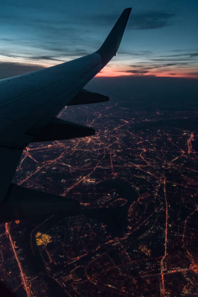 la vista dalla finestra dell'aereo della città notturna - window porthole sky cloudscape foto e immagini stock